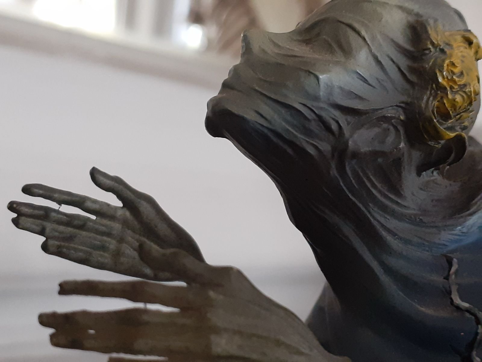 Escultura de una figura con el rostro velado y las manos abiertas